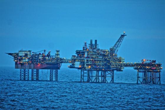 Oljeplatform ute på havet. Masse lys på oljeplatformen.