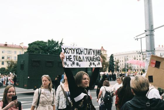 En hviterussisk jente holder en plakat med tekst på russisk under demonstrasjonene høsten 2020. På plakaten står det "Jeg vil ha grunnloven, ikke under Lukashenko"