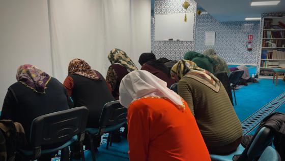 Fargerike, muslimske kvinner som ber i en moské. 