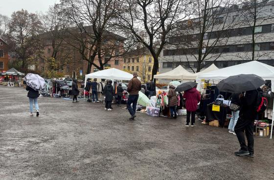 Bildet viser Vestkanttorget og besøkende og det regner