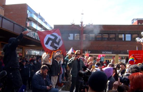 En gruppe motdemonstranter brenner et naziflagg på Tøyen torg i Oslo. 