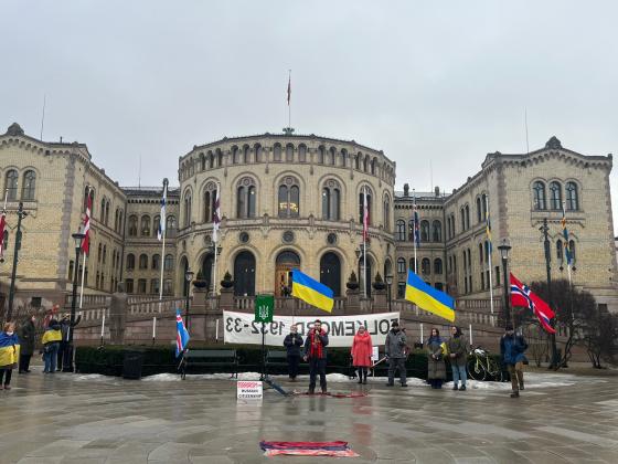 Bildet foran Stortinget med to Ukrainske flagg i forgrunn.