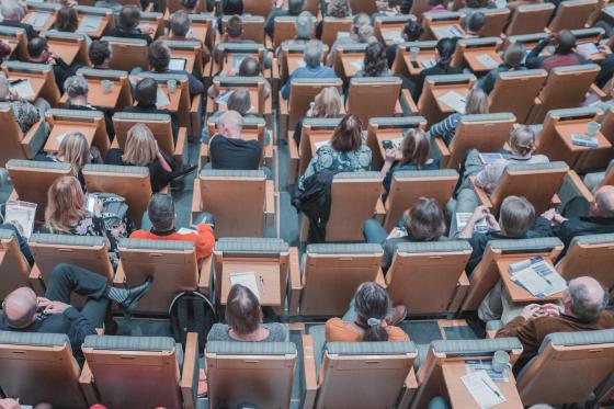 Bilde av studenter som sitter i et auditorium. 