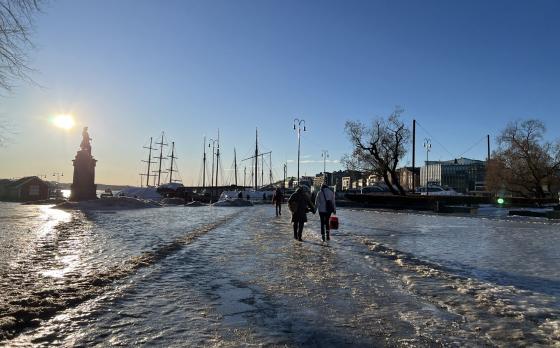 Mennesker som går på isglatt føre i by