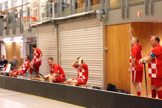 Menn på sidelinjen i en innebandy kamp.