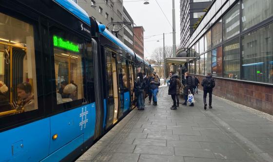 Bilde av et trikkestopp hvor mennersker går inn på trikken.