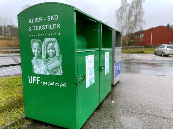 De grønne UFF containeren står på parkeringsplasser utenfor butikker.