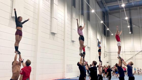 Jenter blir løftet opp i et cheerleaderstunt