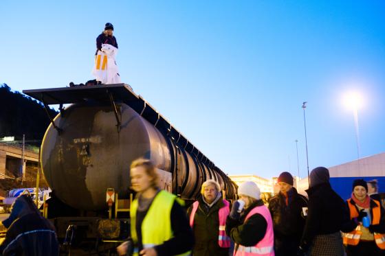 Aksjonister fra Extinction Rebellion myldrer rundt et tog de blokkerer en tidlig morgen i Oslo Havn.