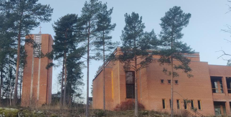 Trær foran en kirke av mur