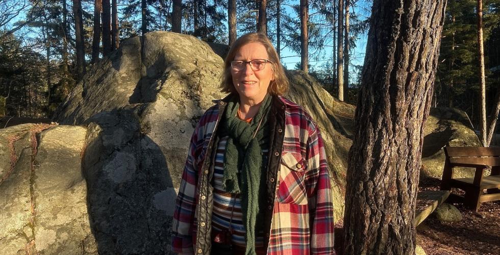 Helga Gunnarsdóttir, styreleder i Østmarkas venner står i sollyset i skogen