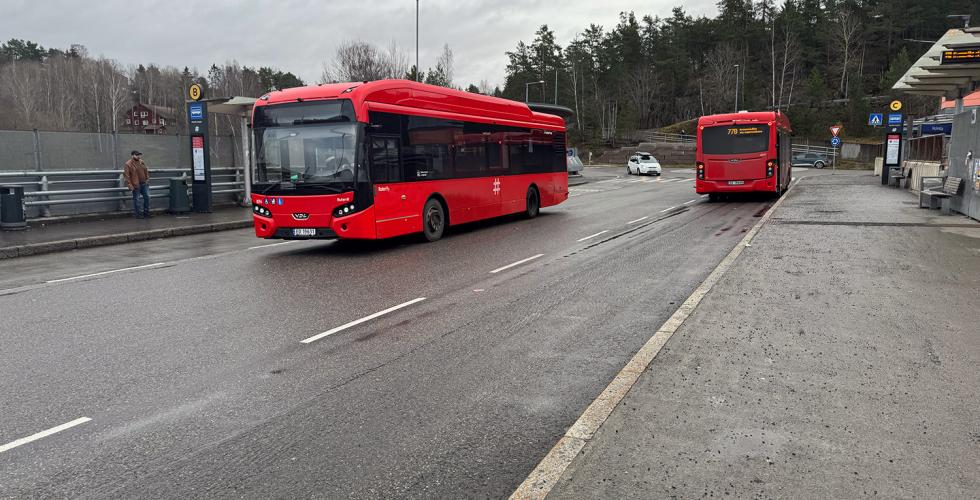 Det er to røde ruter-busser på holdeplassen.