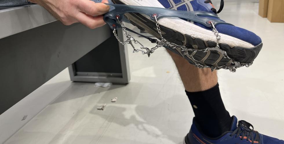 Ansatt på sportsbutikk tar på brodder