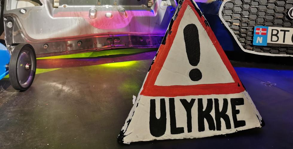 Bildelder og et hjemmelaget ulykkeskilt