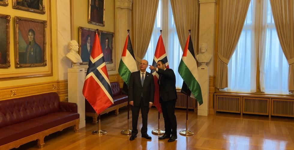 Stortingspresident Masud Gharakhani og Palestinas statsminister Mohammad Mustafa står foran norske og palestinske flagg