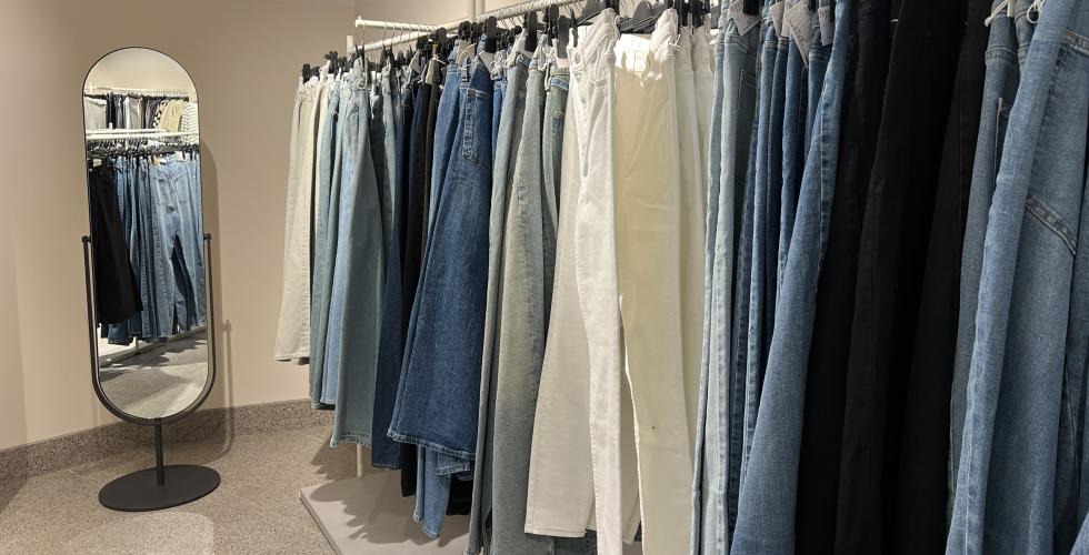 Jeans henger på kleshengere i butikk