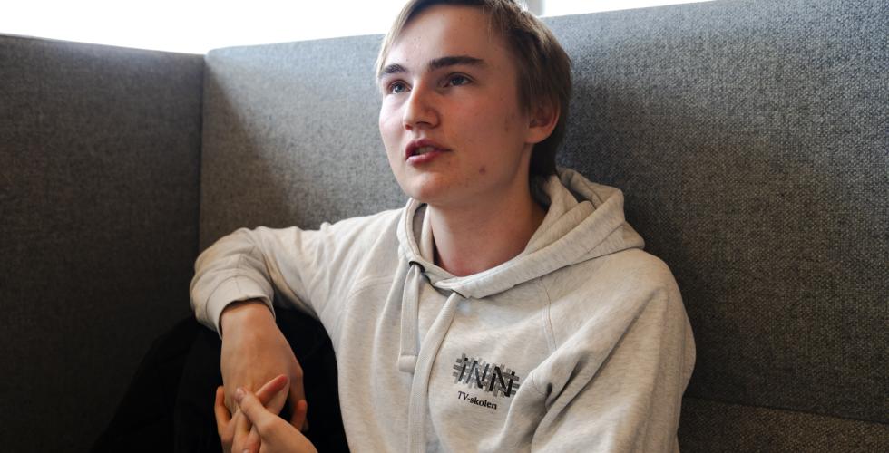 TV-student Kristian Martinsen sitter i en grå sofa og snakker.