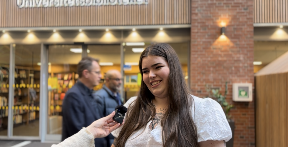 en jente som intervjues, hun smiler etter ferdig intervju utenfor studentbiblioteket