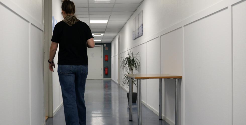 Nav-brukeren går i gangen på kontoret 