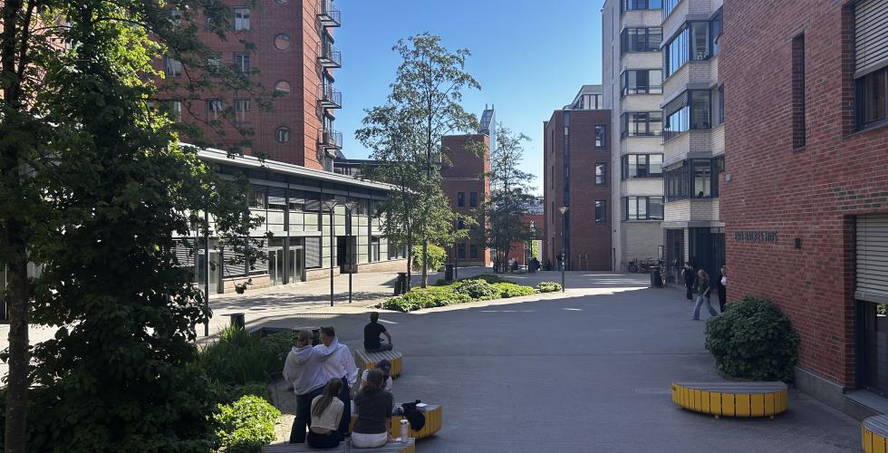 OsloMet campus og elever som sitter på en benk