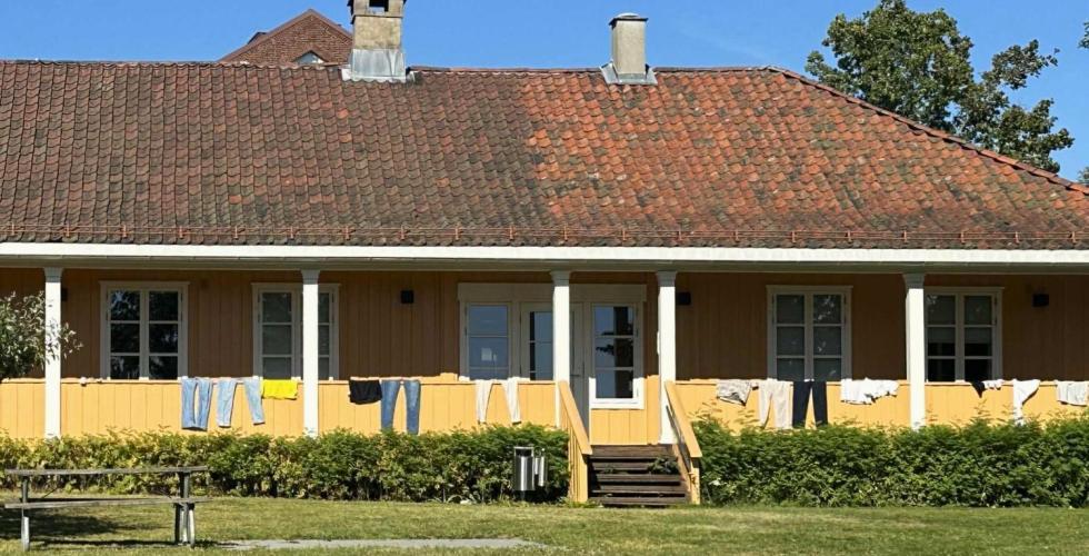 Et gult hus hvor de har hengt klær på gelenderet