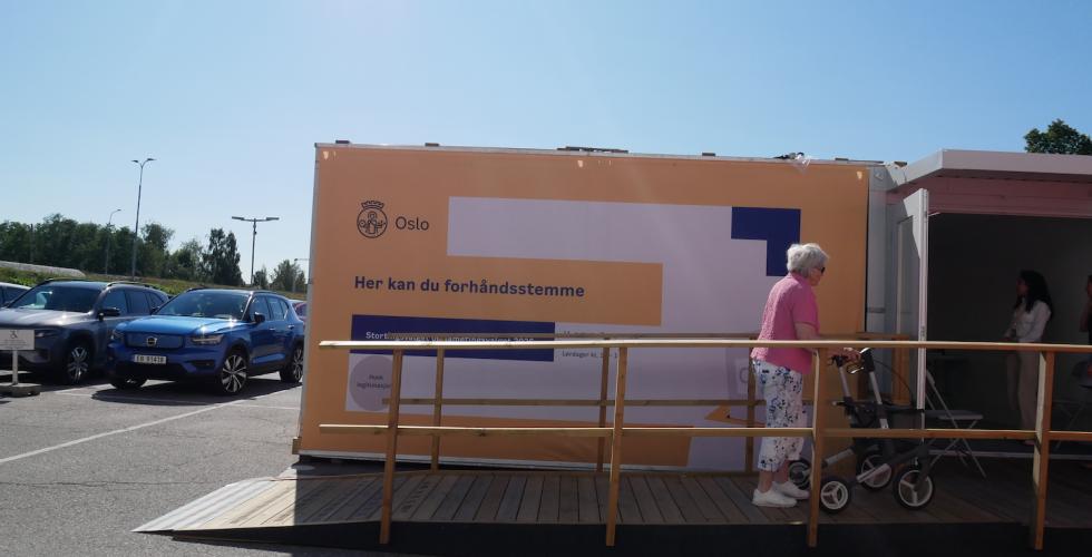 Dame med rullator går inn i stemmelokale