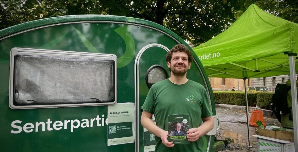 Senterpartipolitiker Øyvind Bentås står stolt foran Senterpartiets stand på Karl Johan
