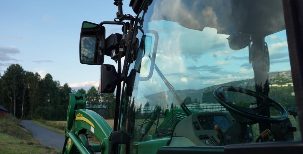 Nærbilde av førersetet til en traktor ved en åker i Bærum
