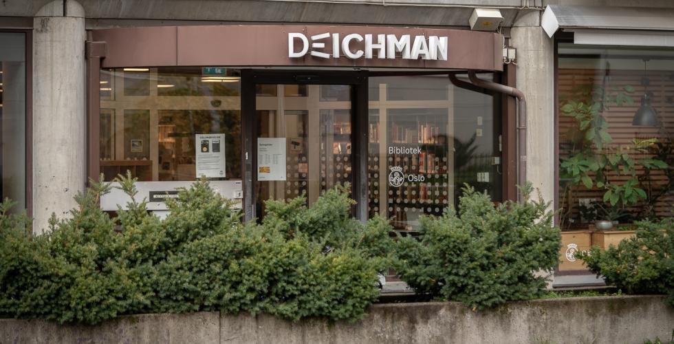 Inngangen til Deichman bibliotek med busker i forgrunnen
