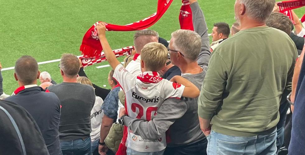 Far og sønn som holder rundt hverandre på fotballkamp