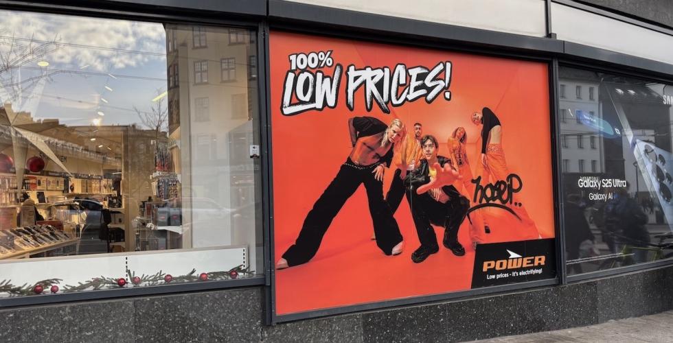 Et reklameskildt for Power hvor det står "100% low prices"