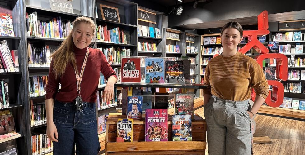 to ansatte på Deichman ved en utstilling av bøker 