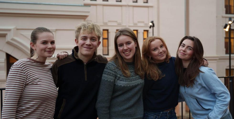 Bilde av revysjefene på Hartvig Nissen skole ute, med skolen i bakgrunnen