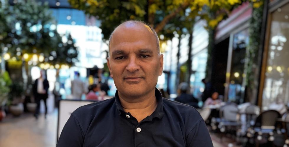 Rashid Nawas som sitter ved et bord, på folketeatret.