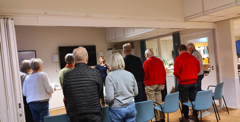 Nordstrand demenskor synger - De står oppreist med ryggen til kamera, koristen synes foran