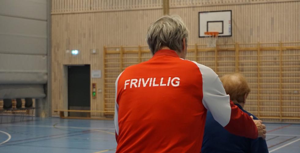 Nærbilde av frivillig som hjelper en med demens