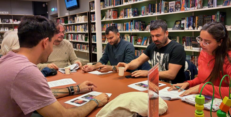 Mennesker rundt et bord på et bibliotek