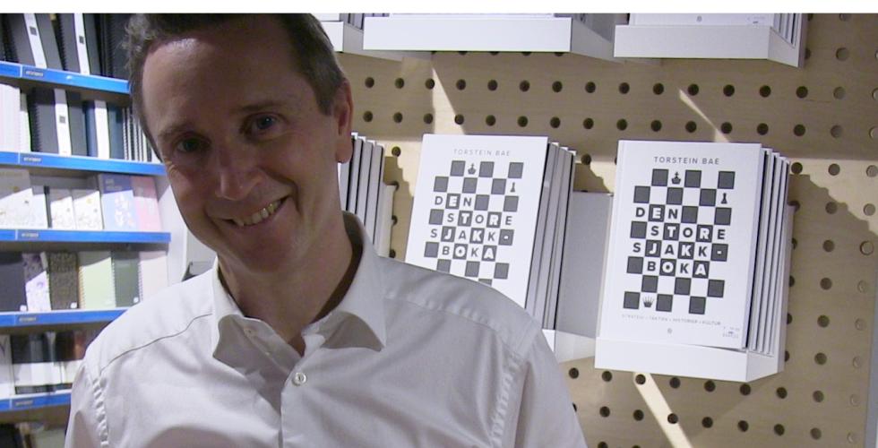 Torstein Bae med boka "Den store sjakkboka"