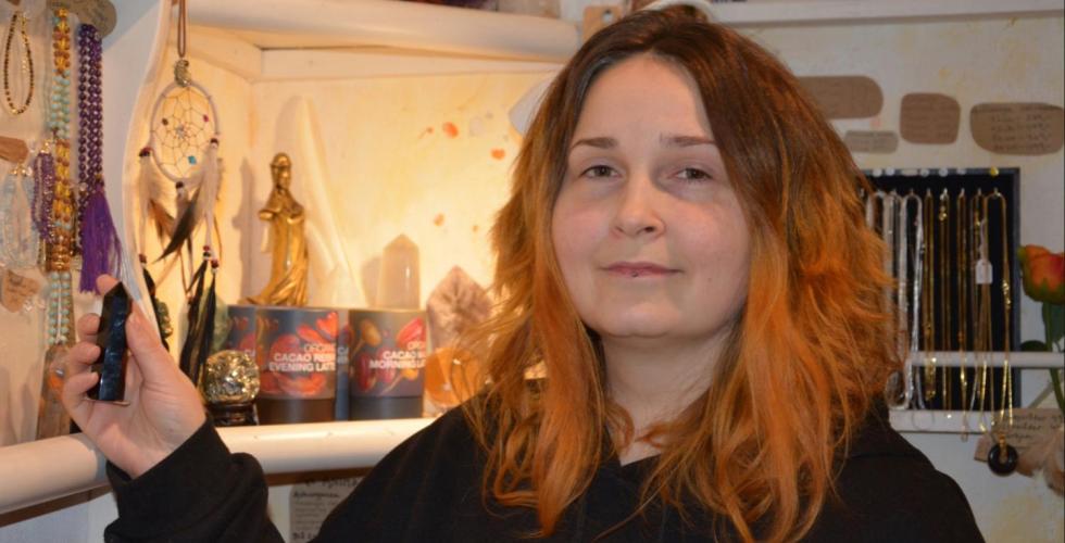 En dame som holder en krystall og ser p&aring; kamera 