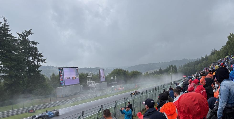 F1-biler som kj&oslash;rer forbi tilskuere p&aring;  Circuit de Spa-Francorchamps i Belgia. 