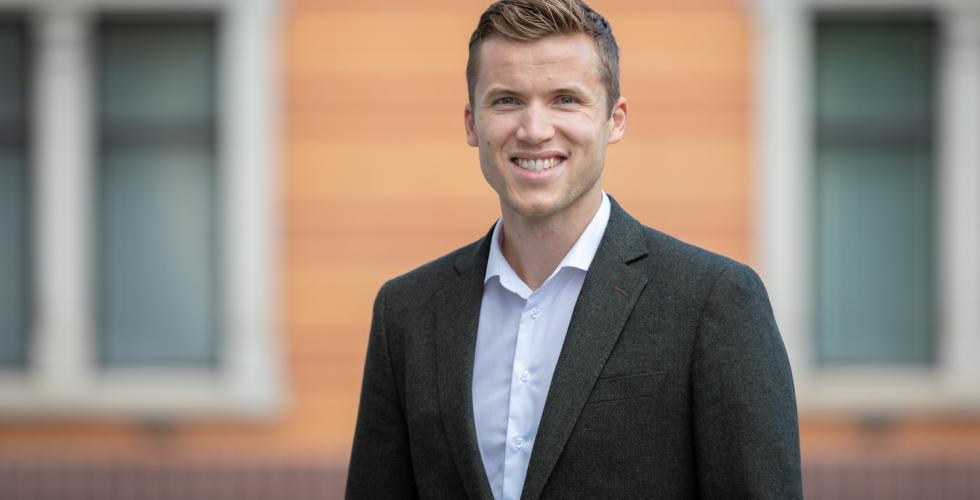 Mann i svart dress og hvit skjorte 