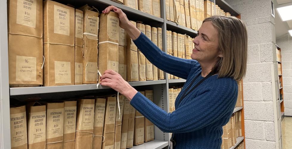 Riksarkivar Inga Bolstad blar i gamle dokumenter