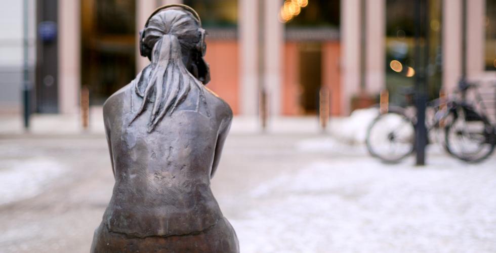 Statue av en jente som sitter foran Norges bank