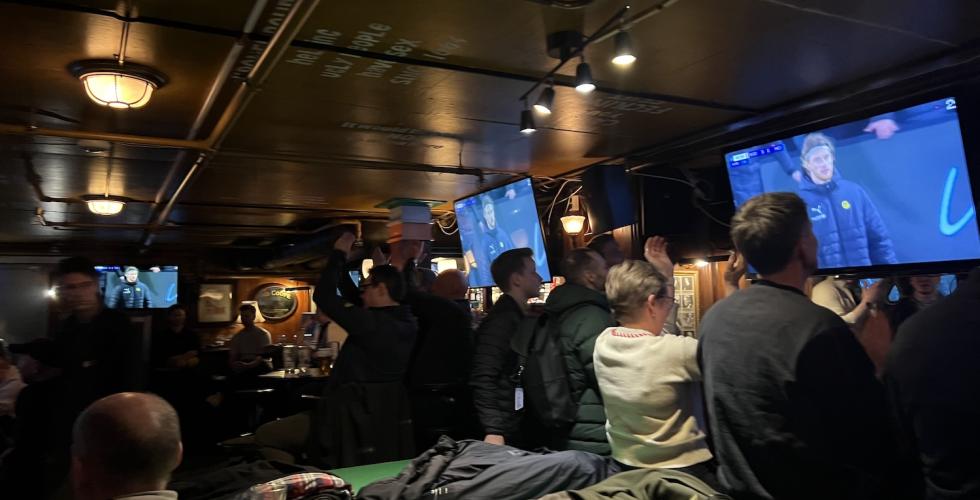 Fotballentusiaster som ser p&aring; fotballkamp i en Sportsbar