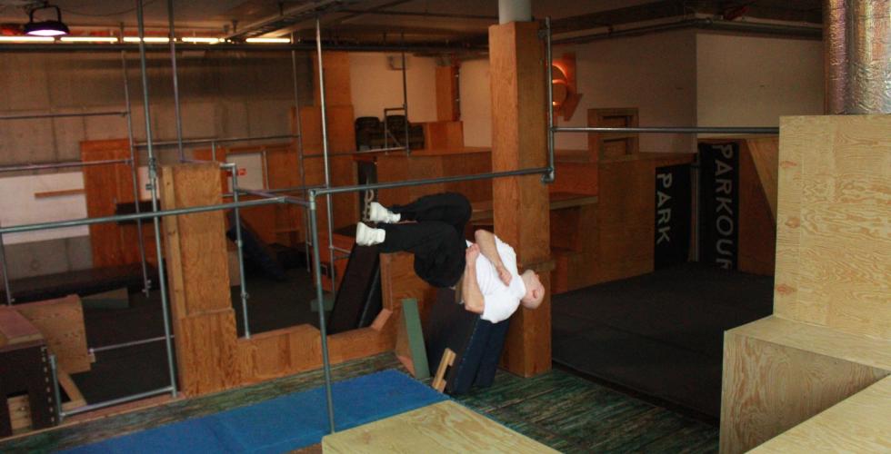 Christian Hansen parkourerer over et hinder i parken.