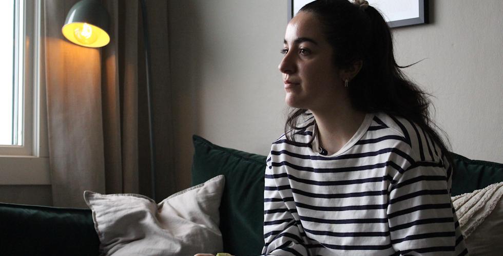 Aurora som sitter i sofaen og spiser frokost 