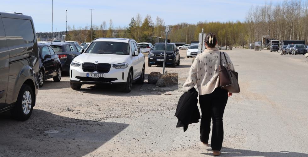 jente med ryggen til som g&aring;r mot bilen sin 