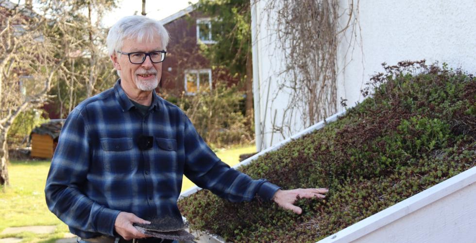 mann som viser frem et gr&oslash;nt tak 