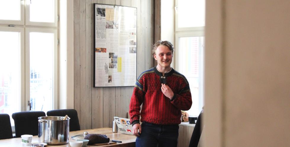 Mann sitter halves opp&aring; ett bord og prater