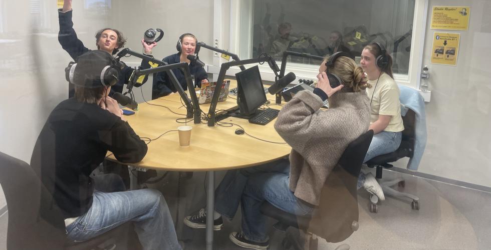 to programledere og tre gjester i radiostudioet